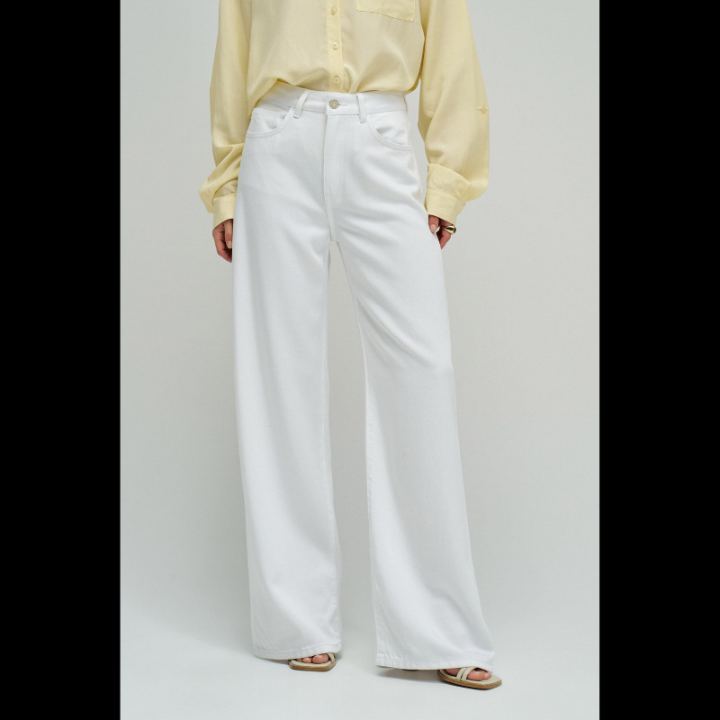 Calças jeans wide leg em branco puro que combinam estilo e conforto. O corte amplo na perna oferece liberdade de movimento e um visual moderno e descontraído. Equipadas com cinco bolsos funcionais, fecho de correr e botão na cintura para um ajuste seguro, além de presilhas para cinto. Peça versátil que funciona tanto em looks casuais como em composições mais sofisticadas.