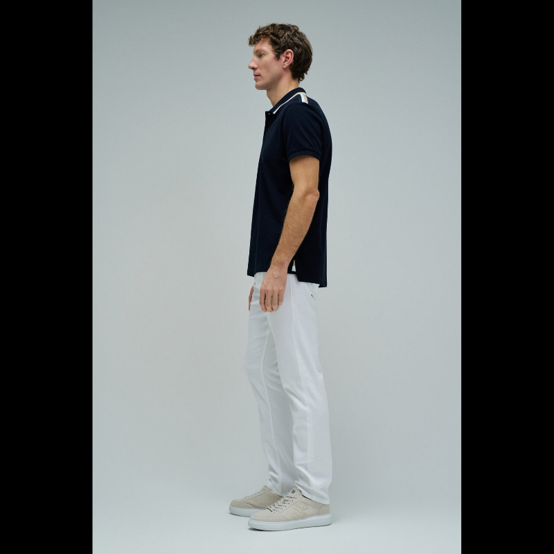 Polo clássico em Marinho com fit regular e mangas curtas. Apresenta decote de colarinho com botões e detalhe de riscas no colarinho que adiciona um toque de sofisticação. Perfeito para um visual casual e versátil, combina conforto com estilo contemporâneo. Ideal para o dia a dia ou ocasiões mais descontraídas.