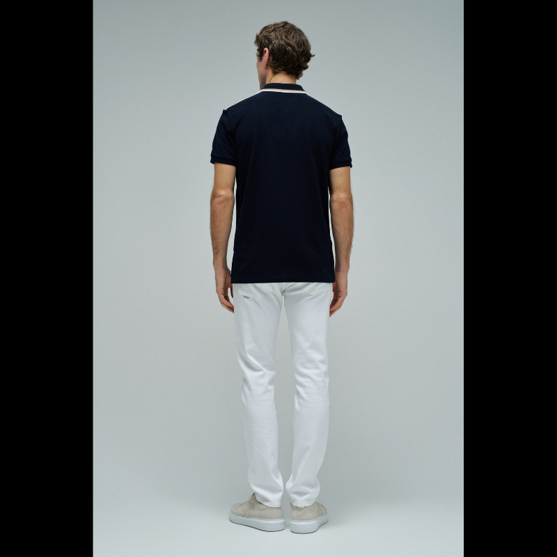 Polo clássico em Marinho com fit regular e mangas curtas. Apresenta decote de colarinho com botões e detalhe de riscas no colarinho que adiciona um toque de sofisticação. Perfeito para um visual casual e versátil, combina conforto com estilo contemporâneo. Ideal para o dia a dia ou ocasiões mais descontraídas.