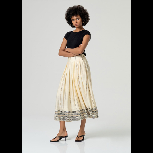 Saia maxi em crú/areia com bordado geométrico estampado em preto e camel que percorre a vertical e a faixa. Apresenta pregas na frente, elástico na cintura traseira e bolsos laterais funcionais. Fecho invisível na lateral garante um acabamento limpo e elegante. Confecionada em viscose e poliamida e com forro, que lhe oferece conforto e fluidez no movimento.
