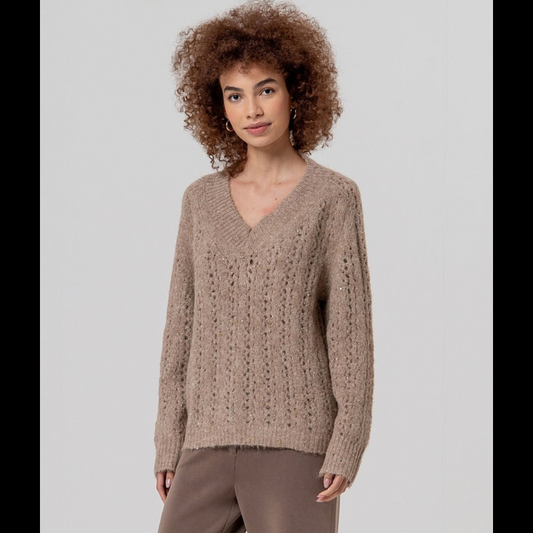 Camisola elegante de manga comprida com decote em V, confecionada em tricô aberto adornado com lantejoulas que capturam a luz.