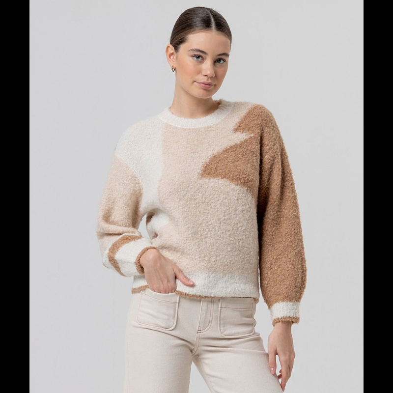 Camisola de manga comprida com decote redondo em tricô texturado. Peça quentinha que combina conforto e estilo, apresentando um padrão geométrico abstrato em tons naturais de bege e castanho.