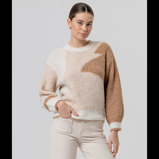 Camisola de manga comprida com decote redondo em tricô texturado. Peça quentinha que combina conforto e estilo, apresentando um padrão geométrico abstrato em tons naturais de bege e castanho.
