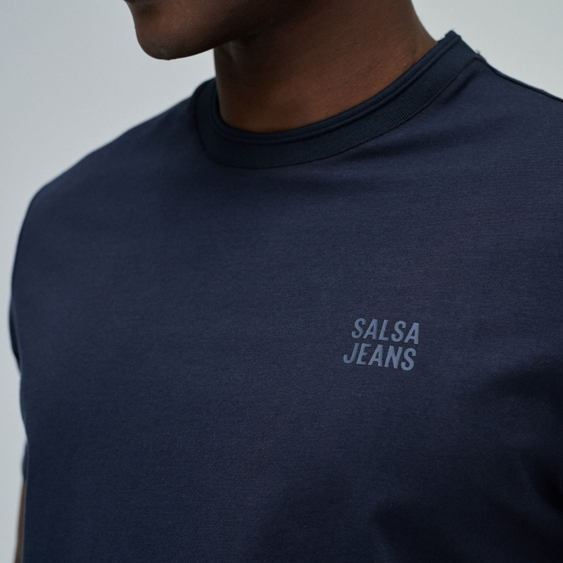T-Shirt azul com branding discreto no peito que reflete um design minimalista sofisticado. O corte slim fit oferece uma silhueta moderna e ajustada, perfeito para composições casual versáteis. T-Shirt de manga curta e decote redondo clássico que garantem conforto durante todo o dia.&nbsp;