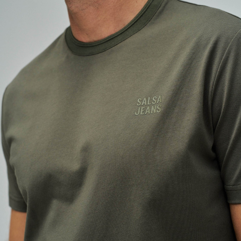 T-Shirt verde em tom contemporâneo com branding discreto no peito que reflete um design minimalista sofisticado. O corte slim fit oferece uma silhueta moderna e ajustada, perfeito para composições casual versáteis. T-Shirt de manga curta e decote redondo clássico que garantem conforto durante todo o dia.