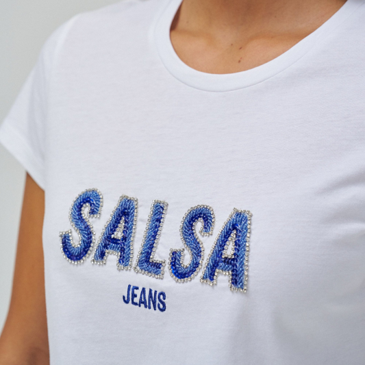 T-Shirt branca, de manga curta e com branding feito com missangas azuis e brilhos. T-Shirt de decote redondo e de corte slim fit.
Composição: 100% Algodão