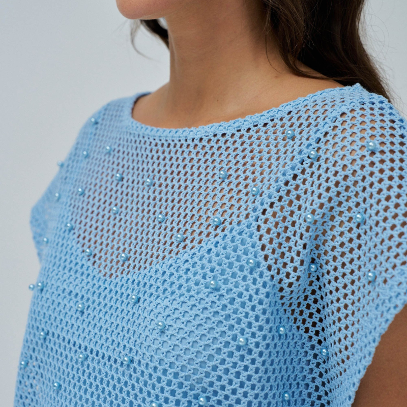 T-Shirt em crochet azul claro com aplicação de pérolas. T-Shirt de corte regular com decote em barco e mangas cavas. Inclui top interior da mesma cor.
Composição: 65% Poliéster + 35% Algodão