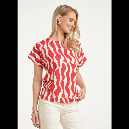 Blusa versátil em tons de vermelho e branco com estampa ondulada que traz movimento e personalidade ao visual. O decote redondo oferece conforto e elegância, enquanto as mangas curtas a tornam perfeita para dias quentes e transições de estação. Ideal para combinar com calças, saias ou shorts, esta peça é um essencial do guarda-roupa que funciona tanto em looks casuais como em ocasiões mais descontraídas.