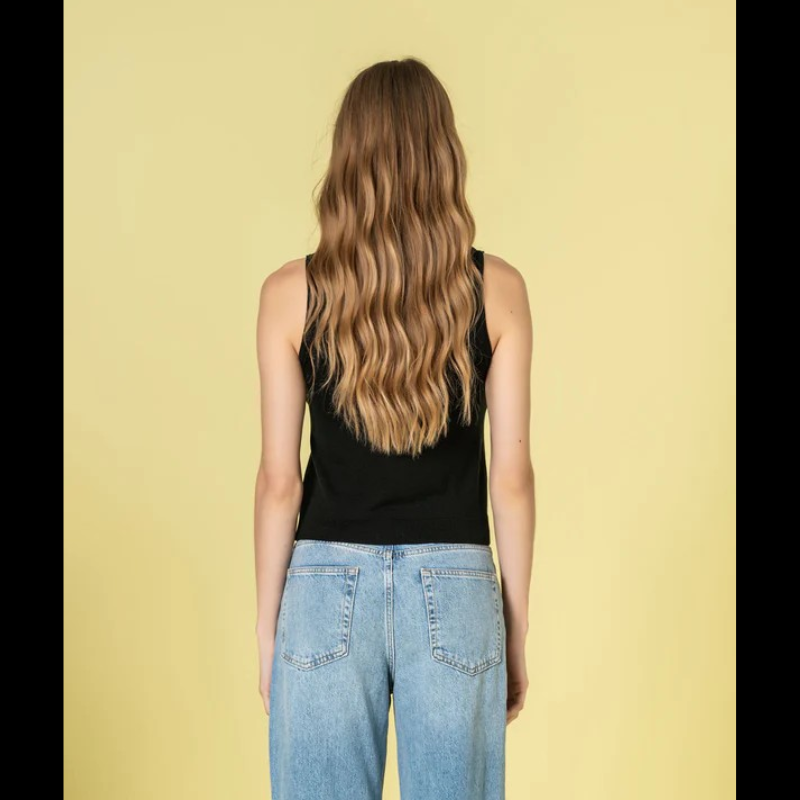 Elegante top de malha com alças largas e decote redondo em preto. Peça versátil que combina conforto e sofisticação, ideal para criar looks modernos tanto no dia a dia como em ocasiões mais descontraídas. A construção em malha de qualidade garante durabilidade e um caimento impecável.