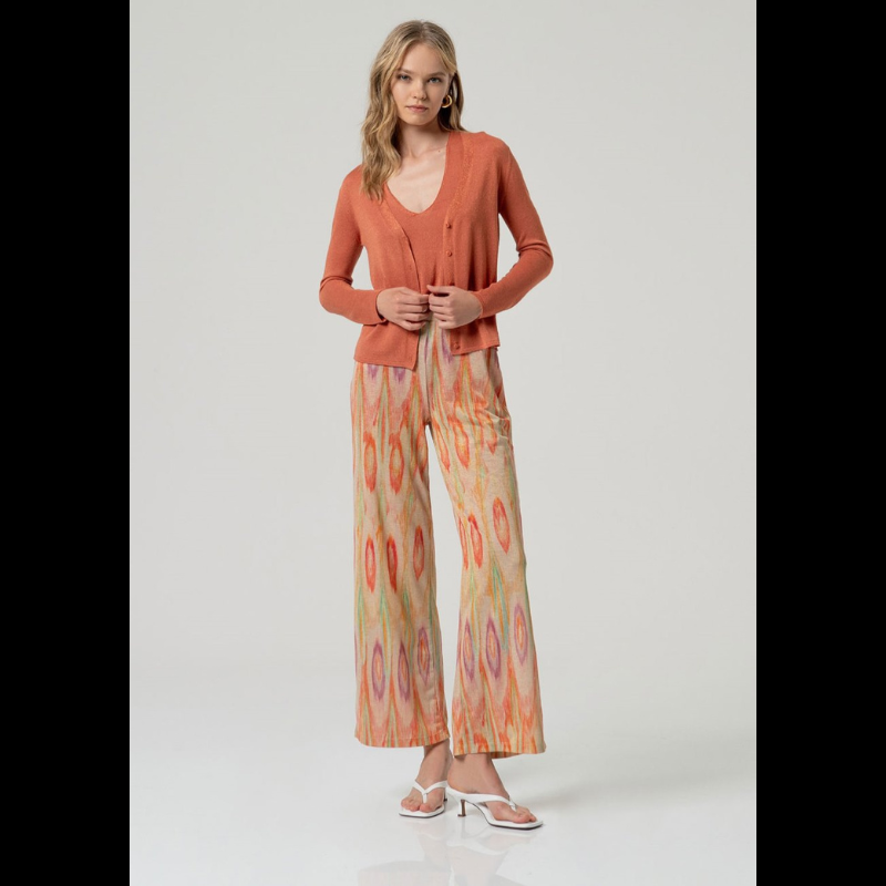 Top confecionado em malha fina de qualidade, de alças amplas e decote em V que realçam a silhueta com elegância. O tom telha enriquecido com detalhes Lurex proporciona um brilho subtil e refinado, tornando-o uma escolha versátil para composições sofisticadas.