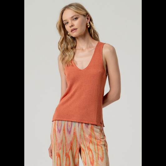 Top confecionado em malha fina de qualidade, de alças amplas e decote em V que realçam a silhueta com elegância. O tom telha enriquecido com detalhes Lurex proporciona um brilho subtil e refinado, tornando-o uma escolha versátil para composições sofisticadas.