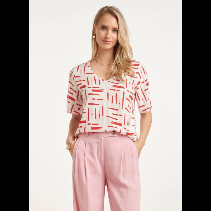 Blusa branca de manga curta com decote em V elegante e moderno. Apresenta um estampado gráfico exclusivo com riscas dinâmicas em vermelho e rosa que trazem movimento e personalidade ao design. Perfeita para criar looks casuais e descontraídos, combina facilmente com calças ou saias do seu guarda-roupa. Ideal para o dia a dia com um toque de estilo contemporâneo.