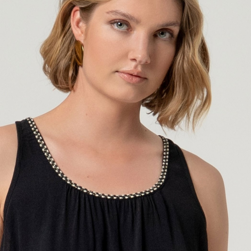 Top de alças em viscose ecovero, perfeito para dias quentes e descontraídos. Decote arredondado com detalhe elegante em preto e dourado que adiciona sofisticação ao visual. Corte solto e suave que oferece conforto máximo, com costas lisas e sem fechamento. Peça versátil que combina com facilidade em looks casuais ou mais refinados.