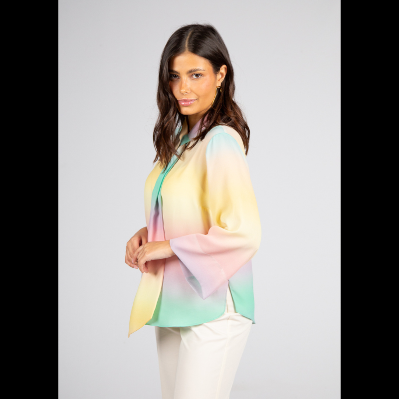 Túnica de decote em V com fita ajustável que oferece versatilidade de uso — mais solta para um visual descontraído ou ligeiramente ajustada para um efeito polido. As mangas compridas reforçam a adaptabilidade a diferentes estações e contextos. Túnica com estampado suave em tons pastel (rosa, amarelo, verde e azul) que cria um efeito etéreo e luminoso e transmite leveza e serenidade. Versátil para ambientes profissionais com calças de alfaiataria ou saias neutras, adapta-se também a coordenados descontraídos