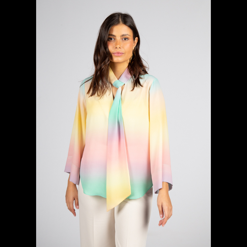 Túnica de decote em V com fita ajustável que oferece versatilidade de uso — mais solta para um visual descontraído ou ligeiramente ajustada para um efeito polido. As mangas compridas reforçam a adaptabilidade a diferentes estações e contextos. Túnica com estampado suave em tons pastel (rosa, amarelo, verde e azul) que cria um efeito etéreo e luminoso e transmite leveza e serenidade. Versátil para ambientes profissionais com calças de alfaiataria ou saias neutras, adapta-se também a coordenados descontraídos