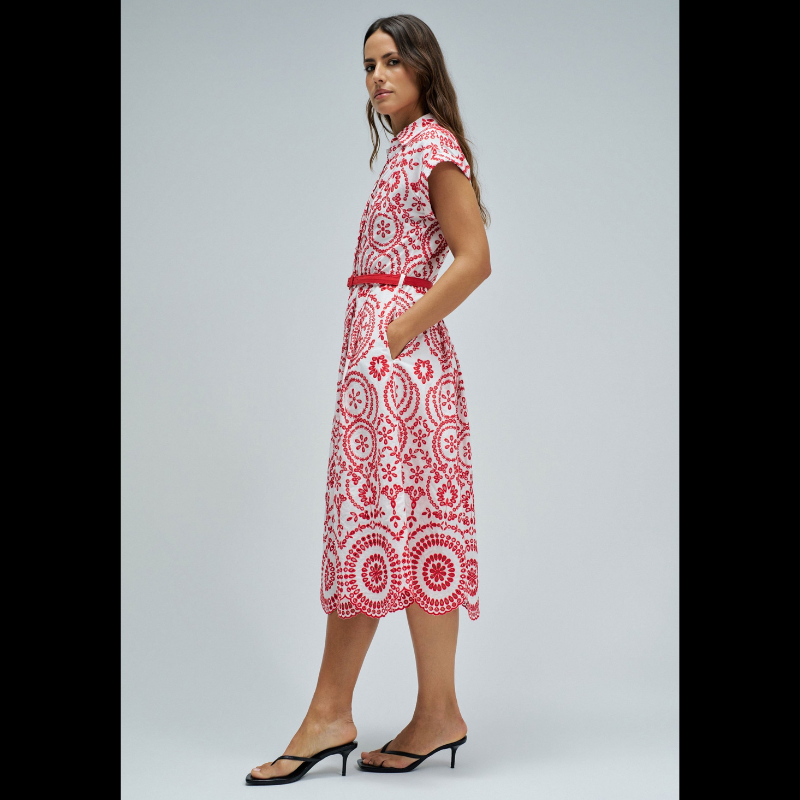 Vestido camiseiro em bordado inglês vermelho, perfeito para um look elegante e sofisticado. Apresenta manga curta, abertura frontal com botões e comprimento midi que favorece qualquer silhueta. Equipado com cinto removível para ajustar o caimento conforme deseja, bolsos funcionais e forro interior para maior conforto. O padrão floral vermelho ilumina o look e reforça a sua expressão mais feminina, com um toque marcante Uma peça versátil que combina com facilidade no seu guarda-roupa do dia a dia.