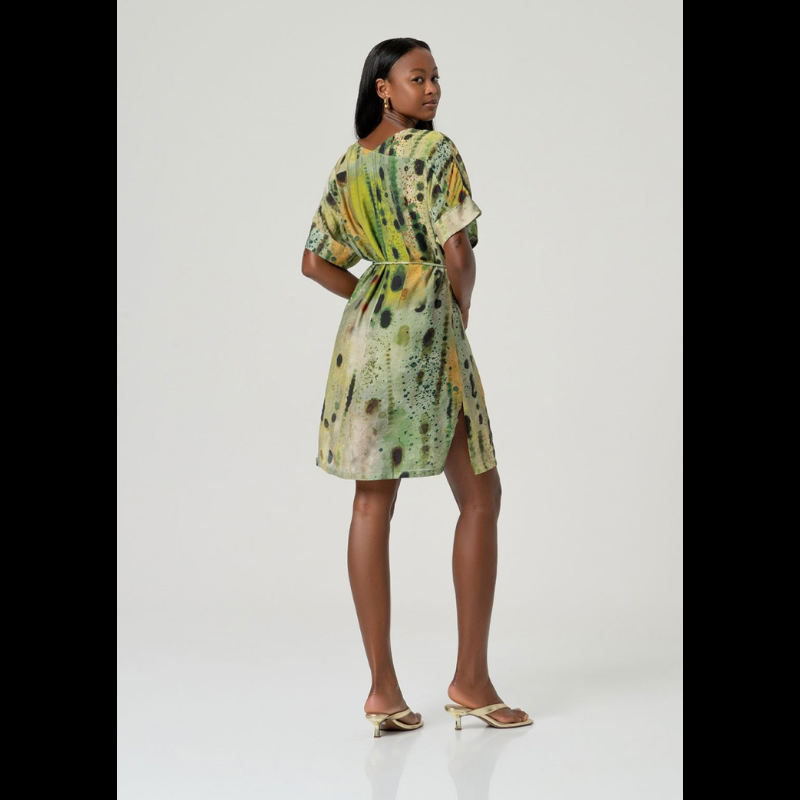 Vestido curto com decote em V e mangas quimono amplas que combinam elegância e conforto. O forro interno e o tecido fluido garantem liberdade total de movimentos, enquanto as aberturas laterais adicionam um toque moderno. O padrão abstrato em tons verdes confere sofisticação e contemporaneidade ao design descontraído. Vestido versátil que pode usar solto ou compor com o cinto fino do mesmo tecido e padrão que o acompanha, tornando-o perfeito para ocasiões casuais com estilo.