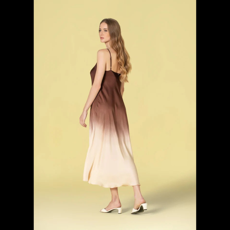 Vestido comprido em acetinado bicolor que combina castanho e bege numa harmonia sofisticada. Alças finas ajustáveis permitem um ajuste personalizado ao seu corpo. Decote em V elegante que enquadra perfeitamente o busto. Peça versátil ideal para ocasiões especiais ou eventos noturnos, oferecendo conforto e estilo em igual medida.