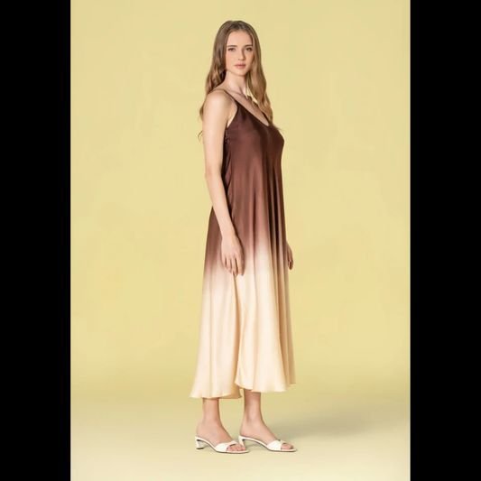 Vestido comprido em acetinado bicolor que combina castanho e bege numa harmonia sofisticada. Alças finas ajustáveis permitem um ajuste personalizado ao seu corpo. Decote em V elegante que enquadra perfeitamente o busto. Peça versátil ideal para ocasiões especiais ou eventos noturnos, oferecendo conforto e estilo em igual medida.