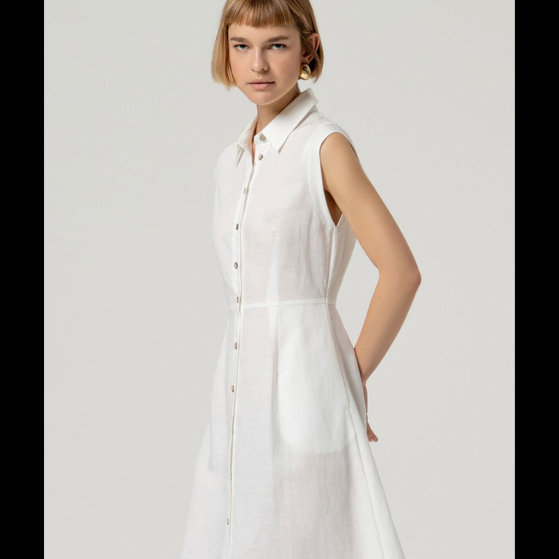 Vestido camiseiro sem mangas em linho e viscose, combinando conforto e elegância. O corte ajustado na cintura realça a silhueta, enquanto a saia em corte envolvente oferece movimento e fluidez. Perfeito para dias quentes, transita facilmente do casual ao sofisticado. Tecido respirável que acompanha o corpo com naturalidade.