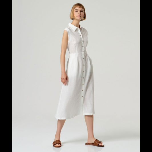 Vestido camiseiro sem mangas em linho e viscose, combinando conforto e elegância. O corte ajustado na cintura realça a silhueta, enquanto a saia em corte envolvente oferece movimento e fluidez. Perfeito para dias quentes, transita facilmente do casual ao sofisticado. Tecido respirável que acompanha o corpo com naturalidade.