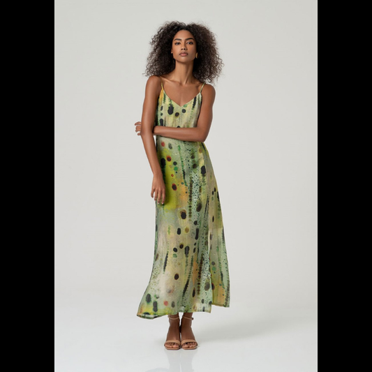 Vestido comprido em viscose e poliamida que combina elegância e conforto. Decote em V com alças finas ajustáveis e fecho invisível nas costas para um acabamento impecável. O corte estruturado no peito contrasta com a saia fluida forrada, enquanto a abertura lateral frontal adiciona movimento e modernidade. O padrão abstrato em tons verdes traz sofisticação a este design versátil, perfeito para ocasiões especiais ou uso do dia a dia elevado.