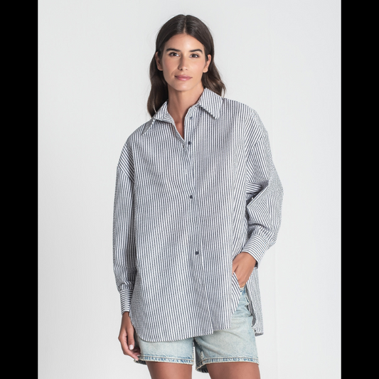 Camisa "oversize" de manga comprida às riscas brancas e cinza. Camisa a fechar na frente e punhos com botões cinzentos. Abertura nas laterias
Composição: 65%Poliéster + 35%Algodão